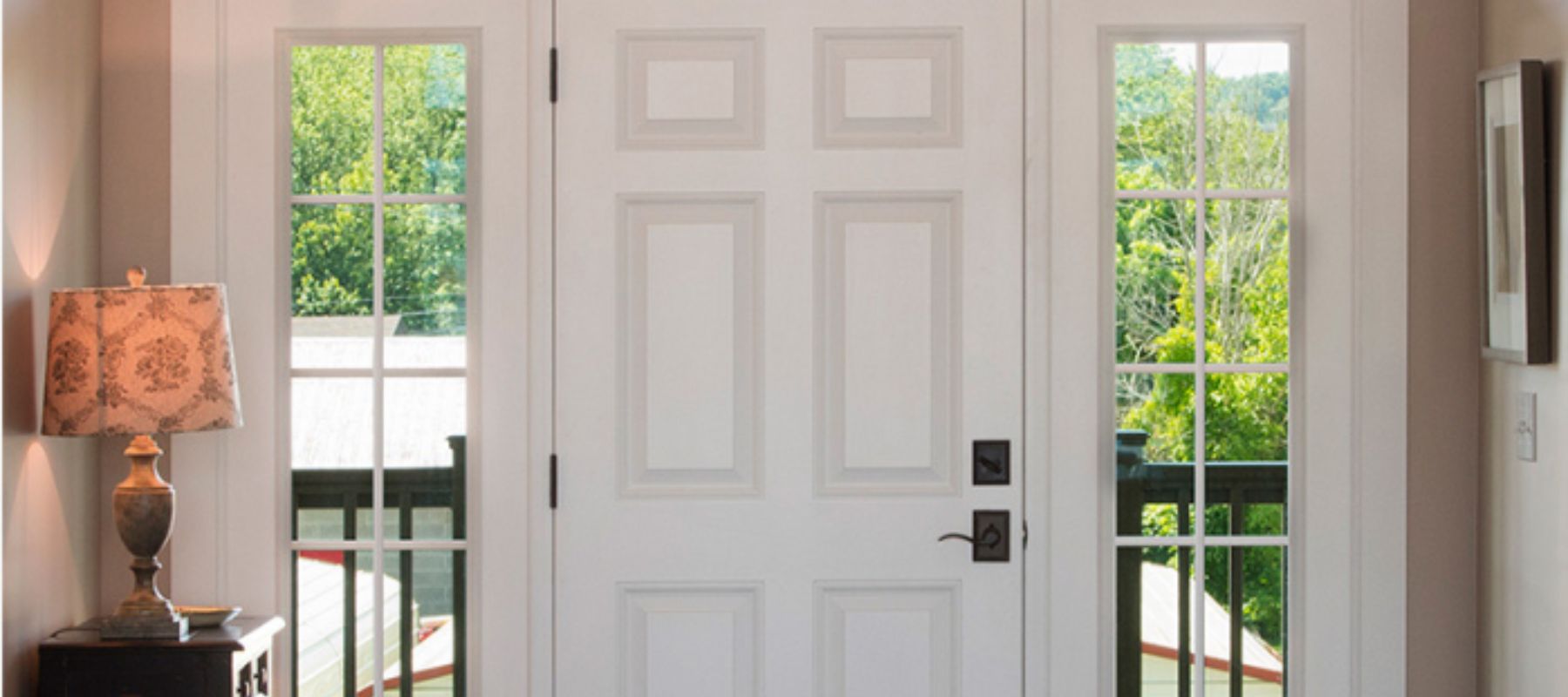 A traditional white entry door with sidelights and a transom window