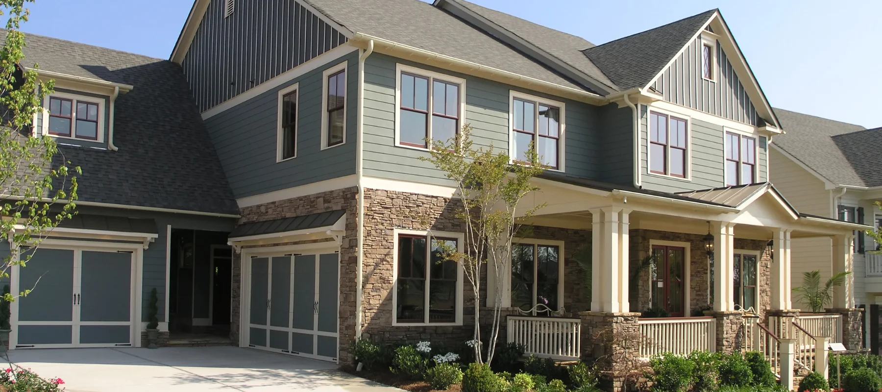 Large two-story home with a mix of stone and board-and-batten siding