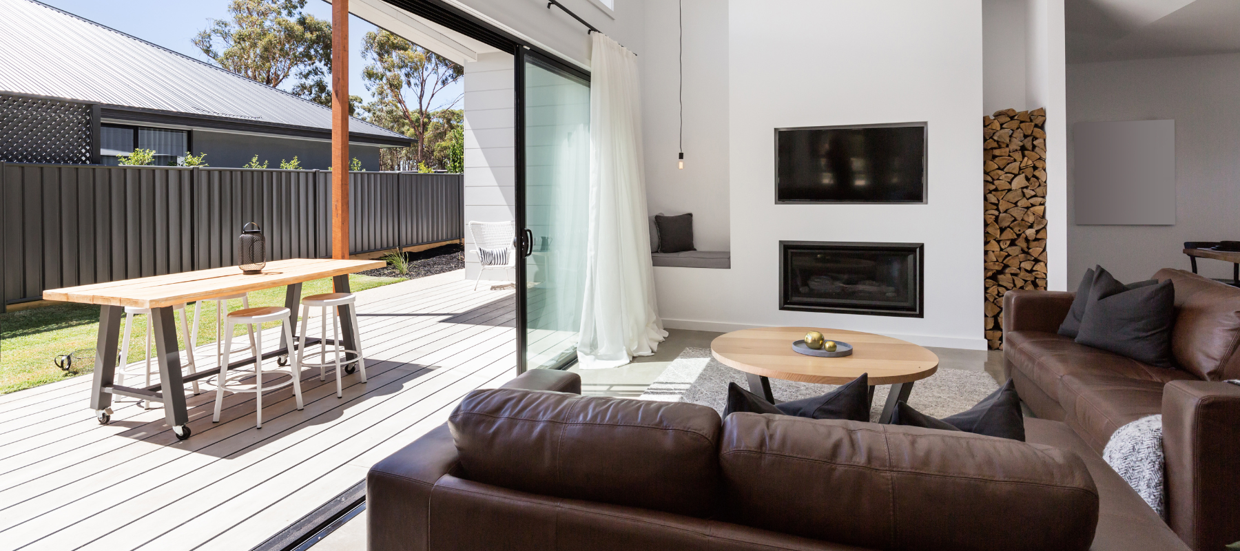 A modern living space with a sliding glass door opening to a backyard deck